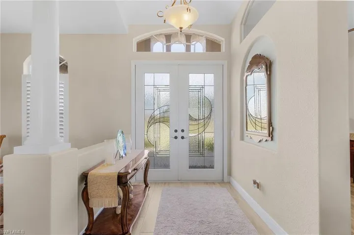Entryway featuring decorative columns, french doors, and light hardwood / wood-style floors