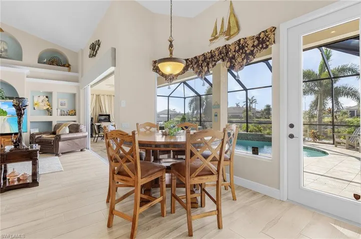 Dining room featuring built in features, high vaulted ceiling, and light hardwood / wood-style flooring