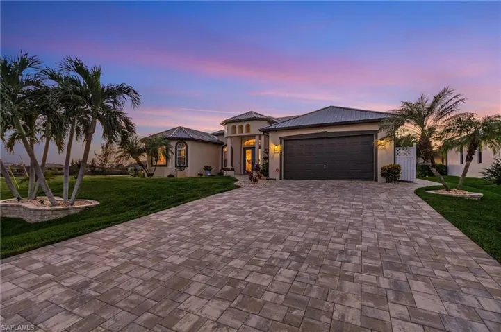 View of front of property featuring a lawn and a garage