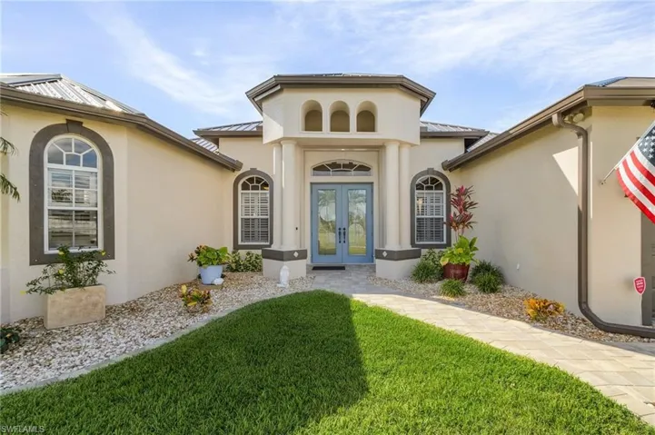 Doorway to property featuring a yard and french doors