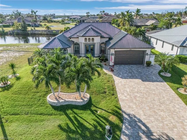 View of front of house with a garage, a water view, and french doors