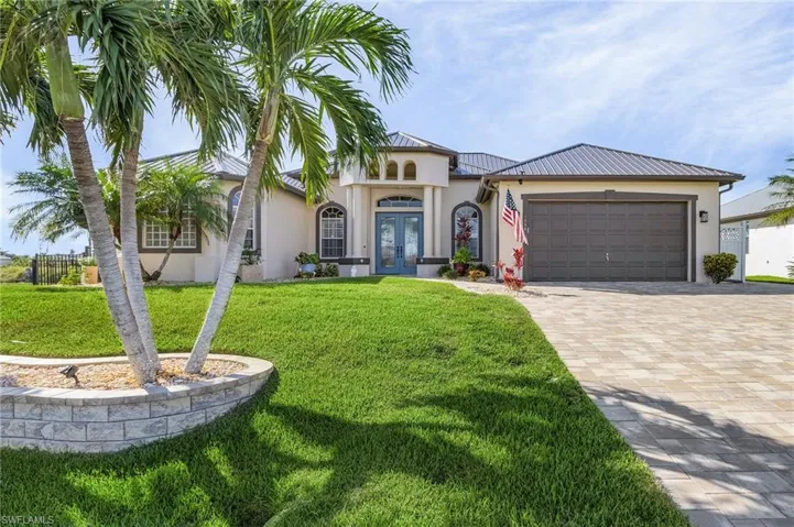 Mediterranean / spanish house with a garage, french doors, and a front lawn