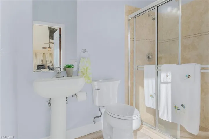 Bathroom featuring a shower with shower door and toilet