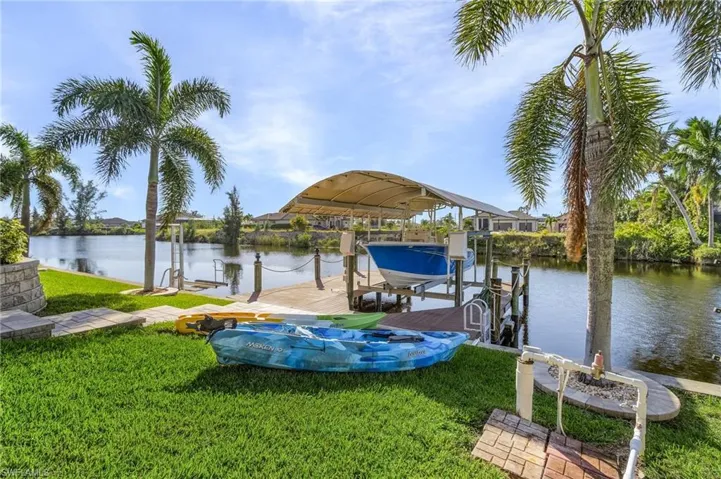View of dock featuring a water view and a lawn