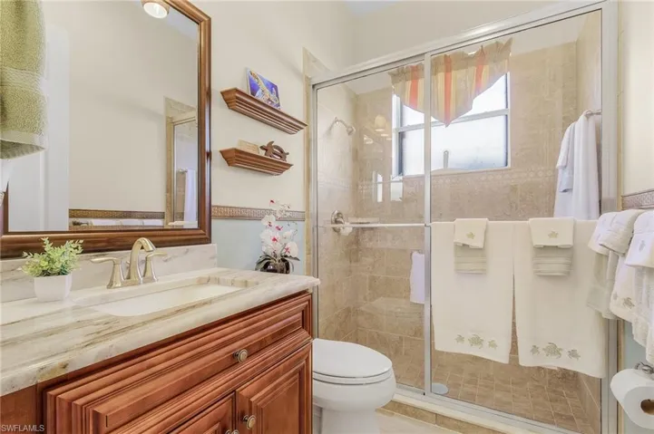 Bathroom with walk in shower, vanity, and toilet