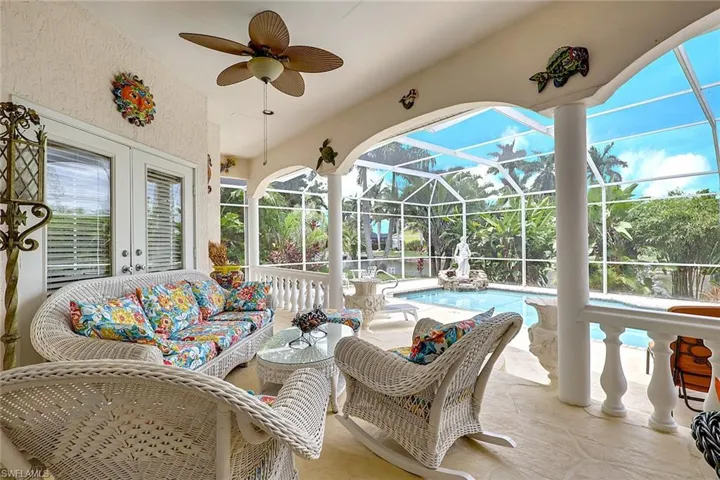 Screened patio with textured ceiling and a ceiling fan, featuring a private pool area with tropical landscaping