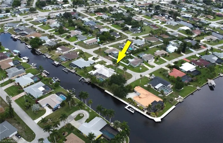 Waterfront property featuring a private boat dock, in-ground pool, and mature landscaping