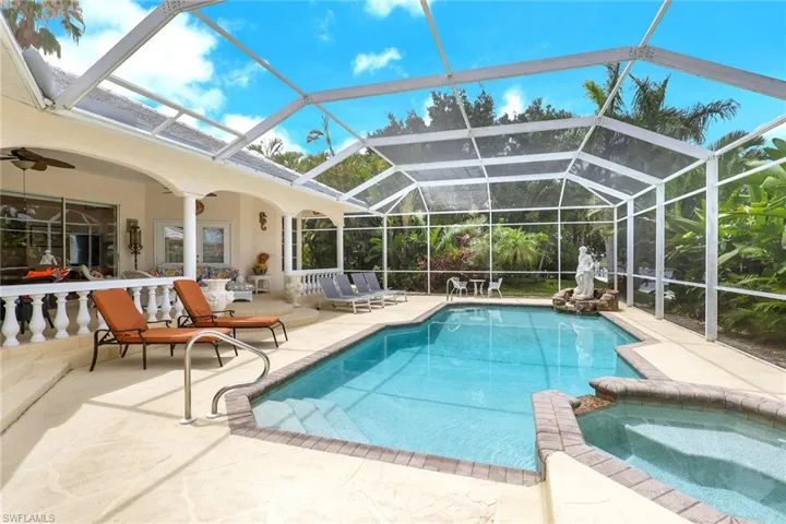 Screened lanai featuring a swimming pool and attached spa with brick coping