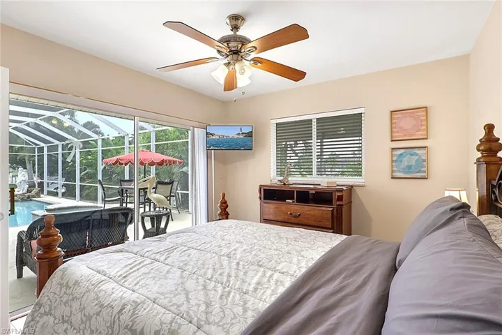 Bedroom featuring a ceiling fan with integrated lighting, a window with horizontal blinds, and direct access to a screened lanai