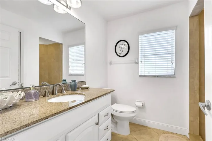 Bathroom featuring a vanity with a light-toned countertop, an undermount sink, and a large wall mirror