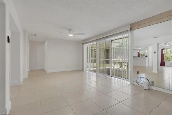 Spare room with a ceiling fan, light tile patterned floors, and a textured ceiling