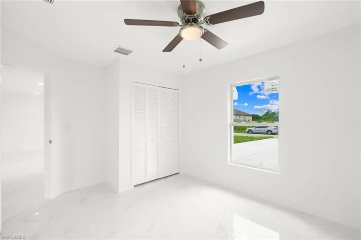 Spare room with tile patterned floors and ceiling fan