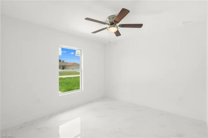 Tiled spare room with ceiling fan