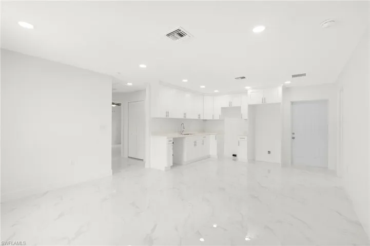 Unfurnished living room with light tile patterned flooring and sink