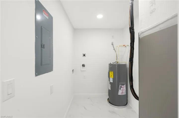 Utility room featuring electric water heater and electric panel