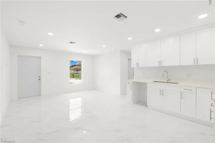 Kitchen with sink, white cabinetry, and light tile patterned floors