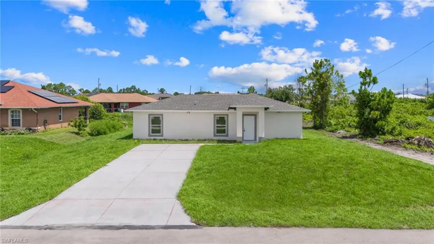 Single story home featuring solar panels and a front yard