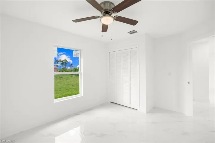 Tiled spare room with ceiling fan