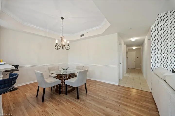 Dining area featuring a chandelier, light hardwood / wood-style flooring, and crown molding
