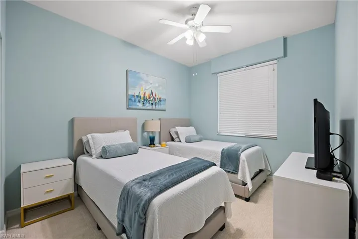 Carpeted bedroom featuring ceiling fan