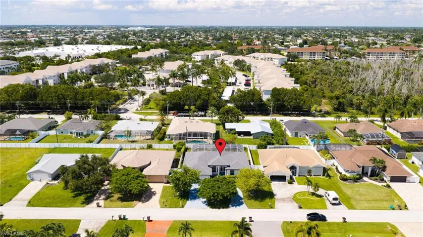 Residential property featuring a swimming pool, attached garage, and paved driveway