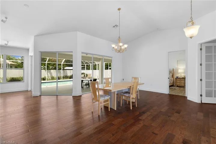 Vaulted ceilings, wood flooring and view of pool and lanai.