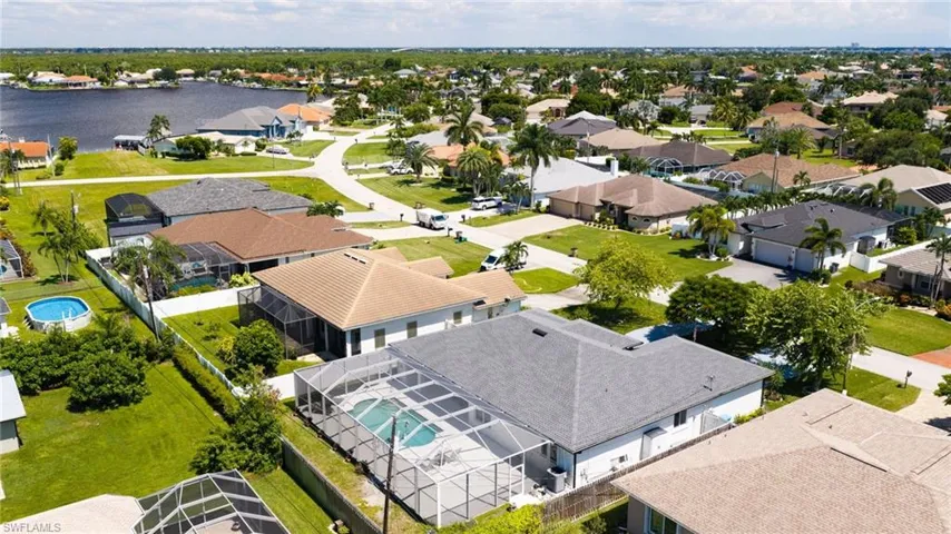 Overhead view showcasing the classic single-story layout, complete with a dark asphalt roof, bright exterior, and seamless attached pool enclosure.