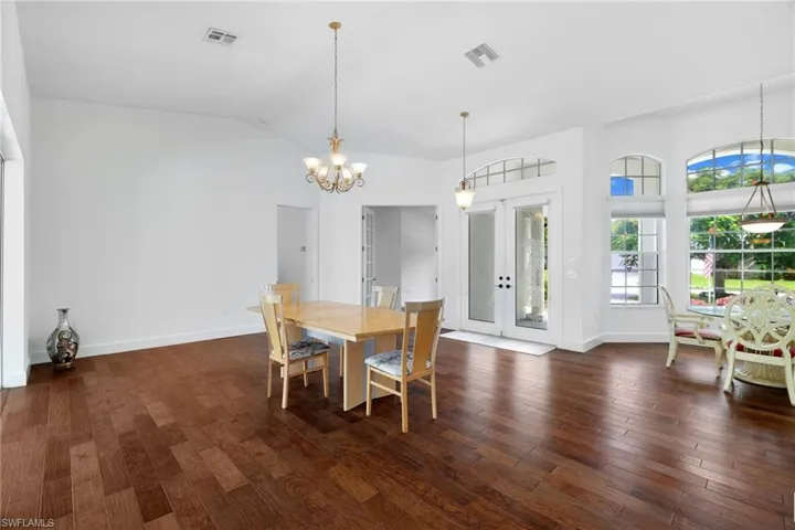 Vaulted ceilings, wood flooring, arched windows, French doors with transom.