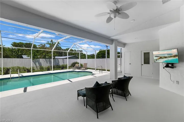 Fully screened pool enclosure with a private rectangular pool, shaded covered patio, and convenient home access.