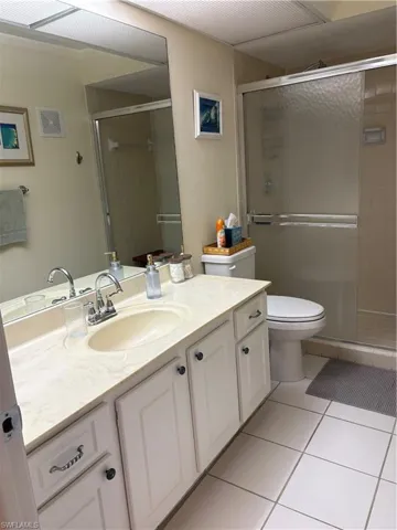 Bathroom with vanity, light tile patterned floors, and a shower stall