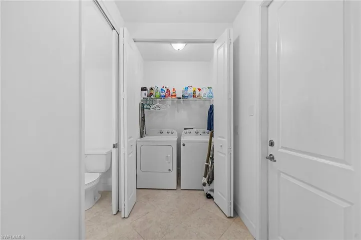 Laundry room with washer and dryer, laundry area, and light tile patterned floors