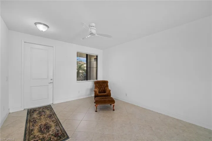 Sitting room with light tile patterned floors, baseboards, and ceiling fan