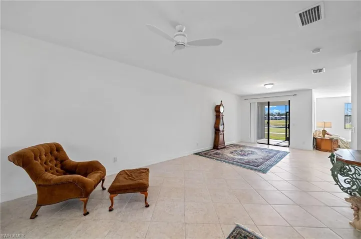 Sitting room featuring light tile patterned floors, visible vents, baseboards, and ceiling fan