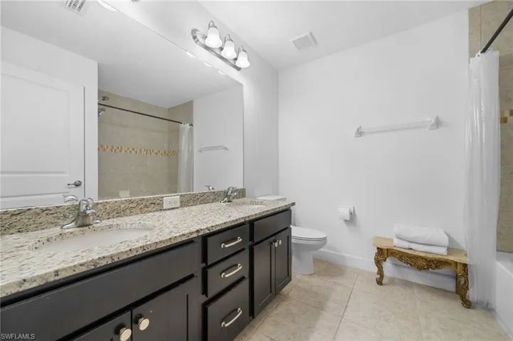 Bathroom with a sink, visible vents, toilet, and tile patterned floors