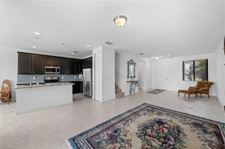 Kitchen featuring decorative backsplash, light tile patterned floors, open floor plan, and stainless steel appliances