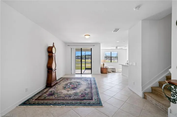 Entryway with stairs, light tile patterned flooring, baseboards, and visible vents