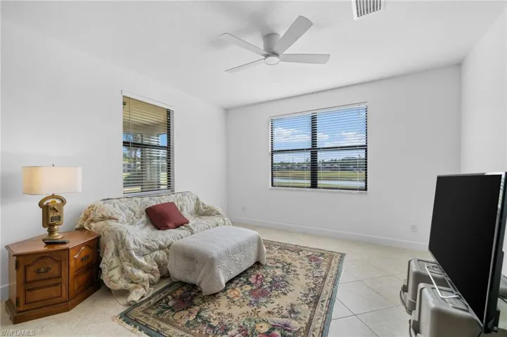 Bedroom featuring light tile patterned floors, visible vents, ceiling fan, and baseboards