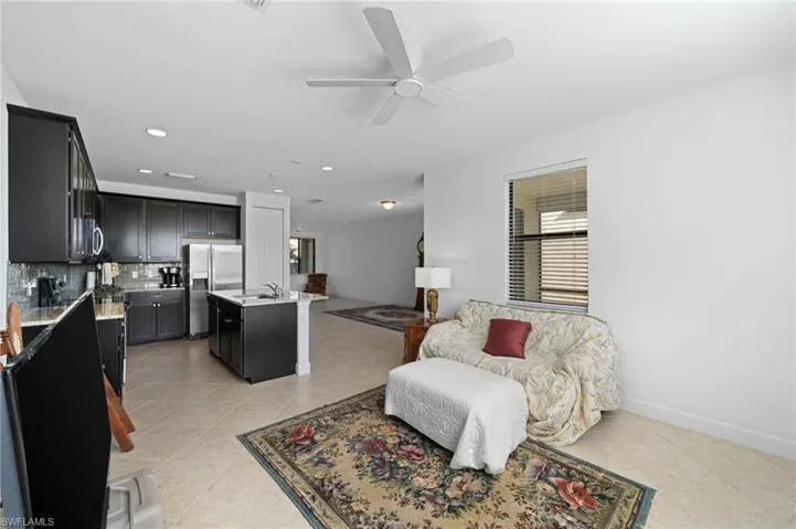 Living room with light tile patterned floors, baseboards, plenty of natural light, and a ceiling fan