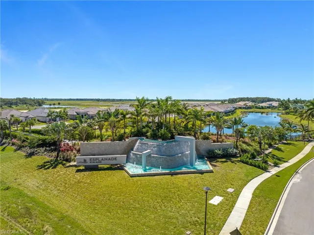 Aerial view of residential area with a nearby body of water and a pool