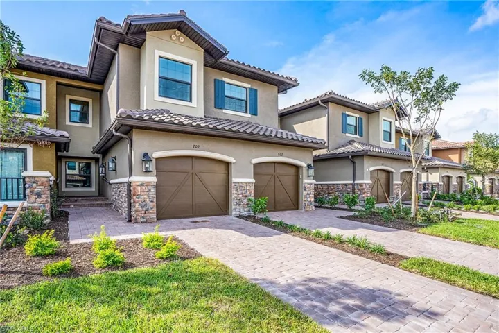 Mediterranean / spanish house with an attached garage, stucco siding, and decorative driveway