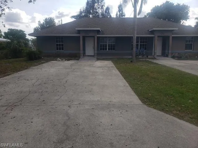 Ranch-style house featuring roof with shingles, a front lawn, and concrete driveway
