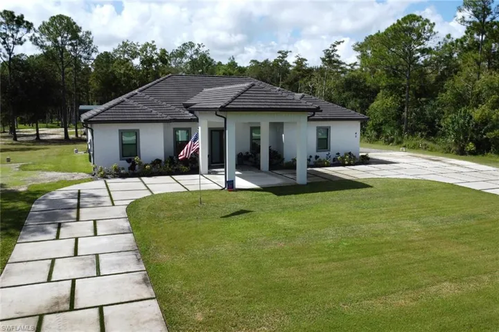 view of house with a yard, a tiled roof, and stucco siding