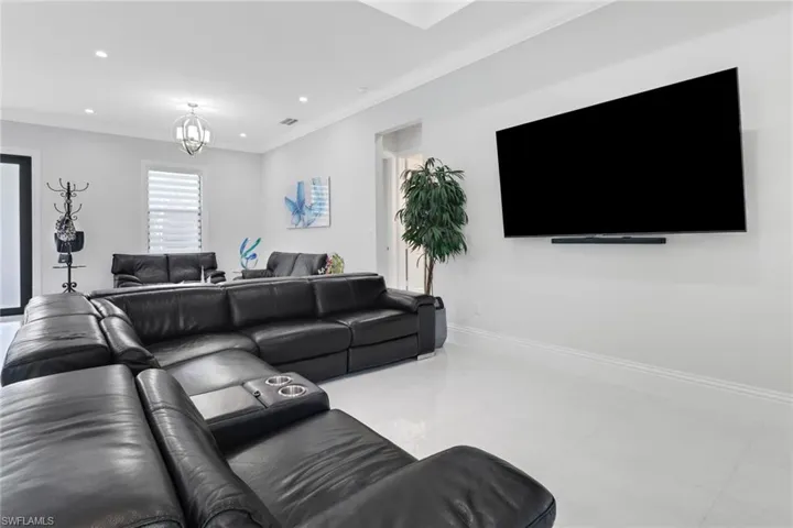 Living area featuring crown molding, recessed lighting, a chandelier, and tile patterned flooring