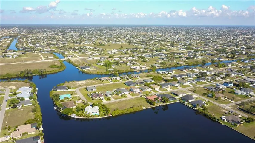 Aerial view of property's location with nearby suburban area and a nearby body of water