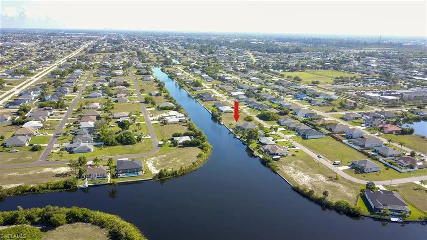 Aerial view of property and surrounding area with nearby suburban area and a large body of water