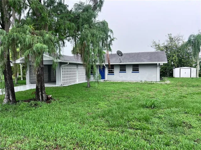 Back of house featuring a yard and a storage shed