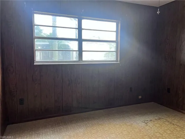 Empty room with tile floors and wood walls