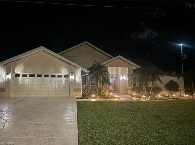Single story home featuring a garage and a yard