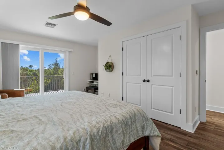 Bedroom featuring ceiling fan, dark hardwood / wood-style floors, a closet, and access to outside