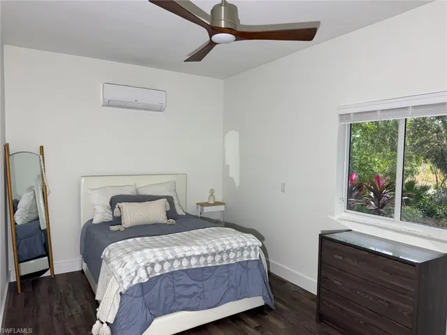 3rd Bedroom featuring dark wood-type flooring, a wall unit AC, and ceiling fan